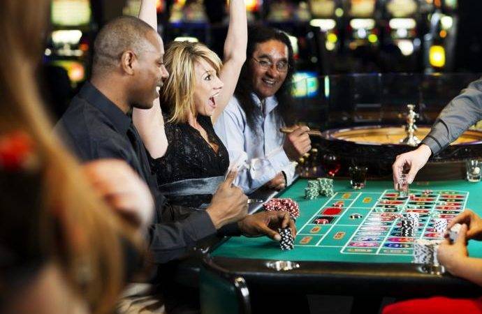 a woman cheering for winning a card game at a casino, surrounded by players