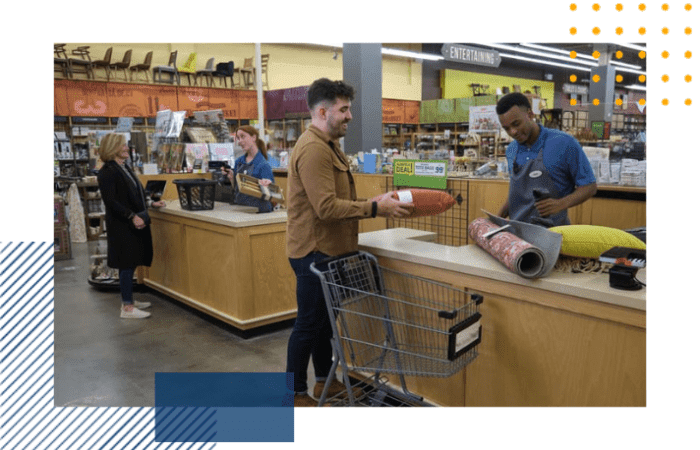 2 employees are checking 2 lines out at a register