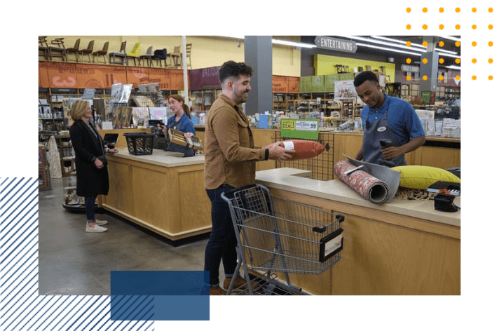 2 employees are checking 2 lines out at a register