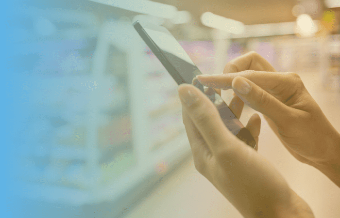 a view of a hand holding a phone in a retail store, and the other hand is touching the screen