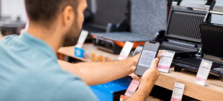 a male customer is scanning a QR code on indoor grill products