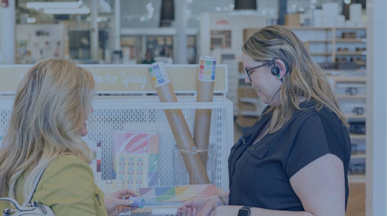 an employee wearing a theatro headset is talking with a customer about some ribbon inventory