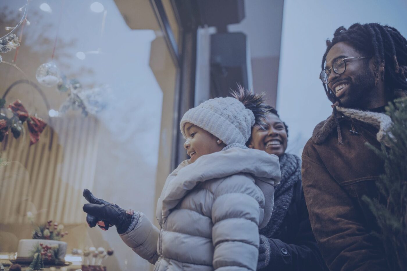 an african-american family window shopping and smiling while father is holding a christmas tree Theatro 2024 Holiday Shopping Report